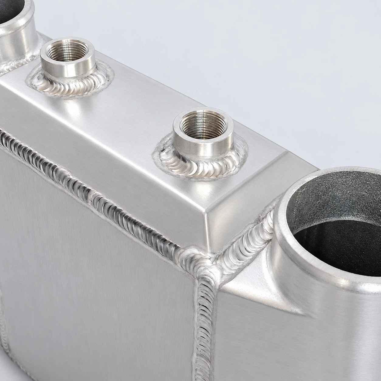 close-up · Threaded coolant connections and welds