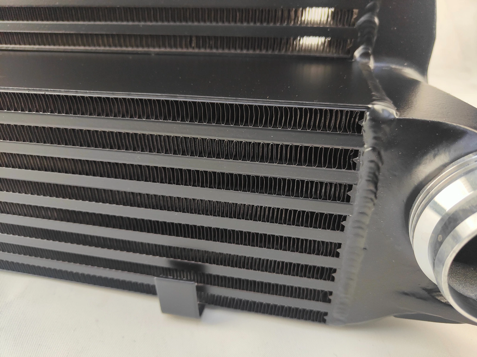 Close-up of the actual black intercooler air-channel fins and end tank weld